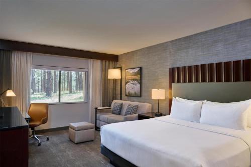 a hotel room with a large bed and a chair at DoubleTree by Hilton Hotel Flagstaff in Flagstaff