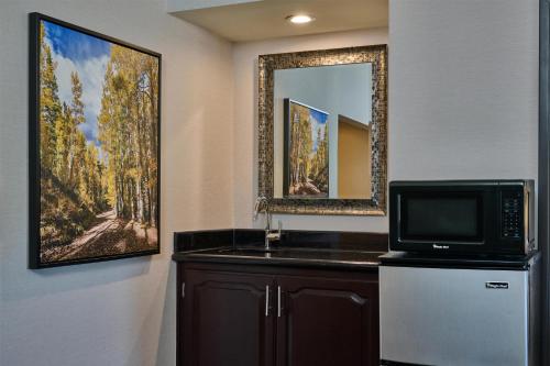 a kitchen with a microwave and a sink and a mirror at DoubleTree by Hilton Hotel Flagstaff in Flagstaff