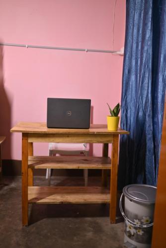a laptop computer sitting on a wooden desk at The Backpackers Hostel in Guwahati