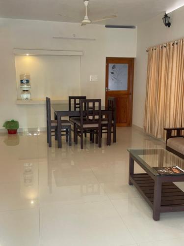 a living room with a dining room table and chairs at Zenways in Varkala