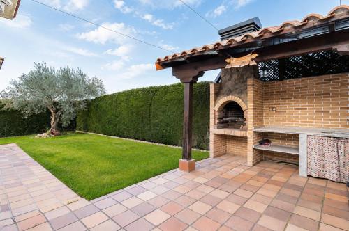 a brick pizza oven in a backyard with a pergola at Casa Turística la Almunia in Castellanos de Moriscos