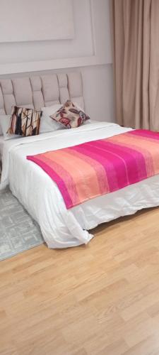 a bed with a colorful blanket on it in a room at Akari said in Rabat