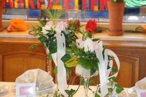 a table with two vases with flowers on it at Hotel Vierjahreszeiten in Breitengüßbach