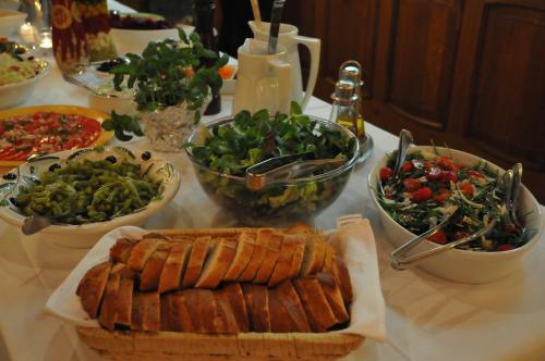 a table with plates of food and bowls of vegetables at Hotel Vierjahreszeiten in Breitengüßbach
