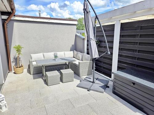 a patio with an umbrella and a table and a bench at Nicos Ferienwohnung in Grevesmühlen - ABC628 in Grevesmühlen