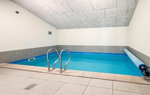 a swimming pool with blue water in a room at Nice Home In Haderslev With Sauna in Haderslev