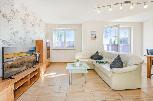 a living room with a couch and a flat screen tv at Ferienhaus Ulme in Kachlin