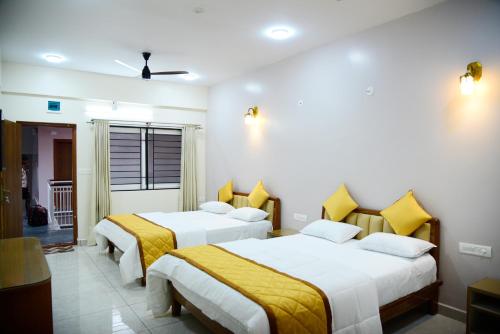 a bedroom with two beds with yellow sheets at Aldur Residency in Aldūr