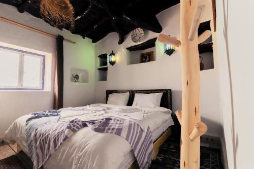a bedroom with a bed with a wooden ladder at Ifni Sunset in Sidi Ifni