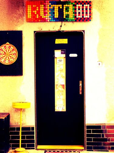 a black door on a building with a sign on it at Ruta 80 Hostel in Brno
