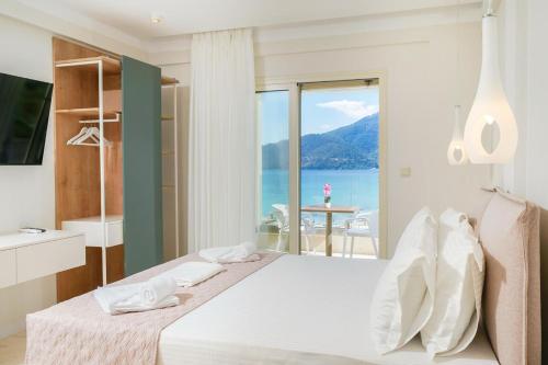 a bedroom with a bed with a view of the ocean at Synthea Suites in Chrysi Ammoudia