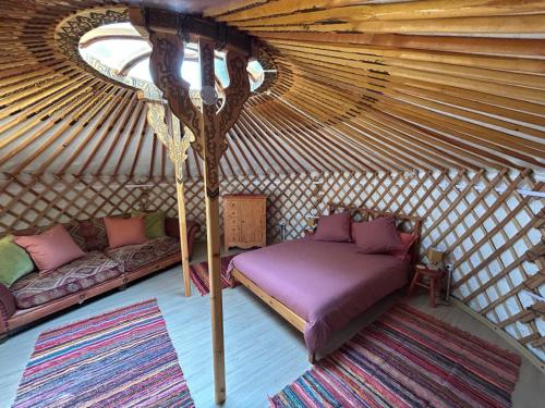 a room with a bed and a couch in a yurt at The yurt at Gites 474 in Sallèles-dʼAude