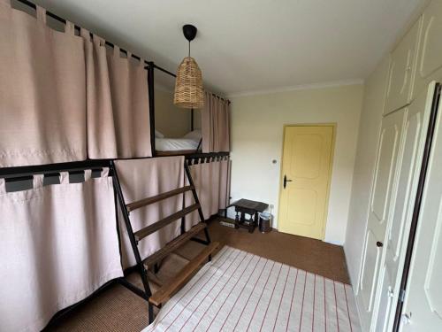 a bedroom with a bunk bed with a ladder at Maceda Surf Camp in Maceda