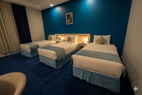 a hotel room with two beds and a blue wall at فندق برهان الهدى in Mecca