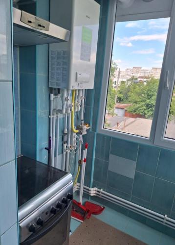 a kitchen with blue tiled walls and windows at Vibe Apartament 17 in Galaţi