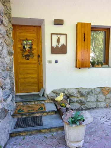 a house with a wooden door and a potted plant at Lu Cheur ad Zona Verde in Limone Piemonte