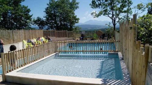 a swimming pool with a wooden fence and a swimming pool at Camping 2 étoiles - Piscine - ccbgcid in Belloc