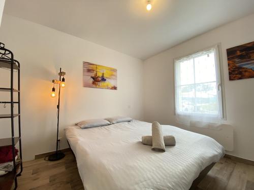 a bedroom with a white bed with a towel on it at La Maison Moderne - 6 pers - SPA - Piscine in Saint-Sauveur-dʼAunis
