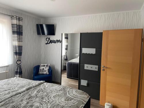 a bedroom with a bed and a blue chair at Ferienwohnung Hubertus in Irsch