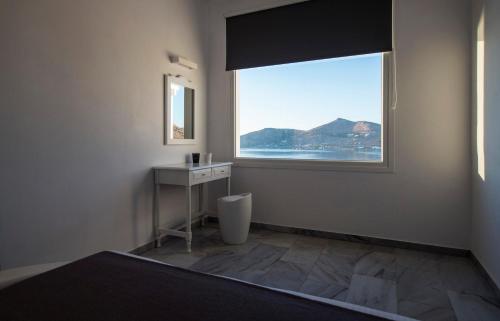 a bathroom with a window with a sink and a toilet at Villa Irini in Naousa