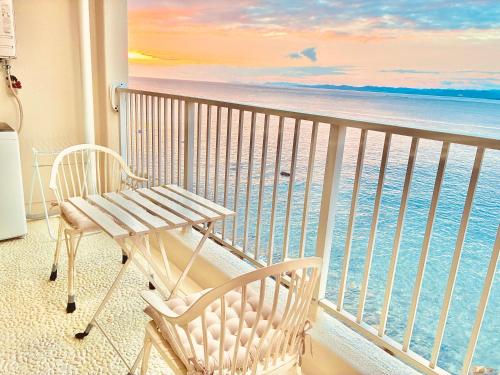 a balcony with a bench and the ocean at Ajisai Coral Princess Villa in Shirahama