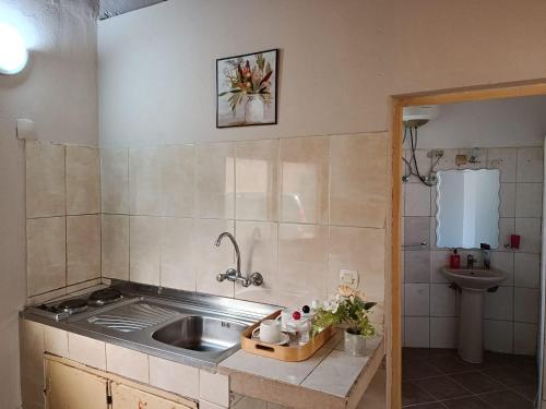 a small kitchen with a sink and a sink at The Huts in Vila Praia Do Bilene
