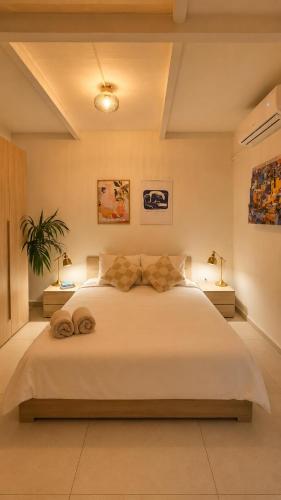a bedroom with a large white bed with two lamps at Aime's House in Sliema