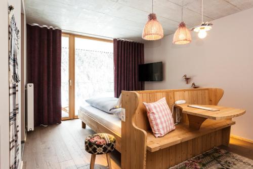 a bedroom with a bed and a table and a desk at Langtaufererhof in Melago