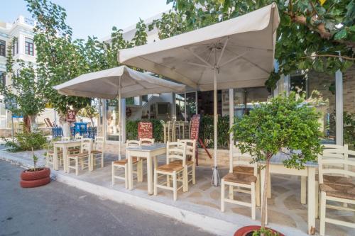 a group of tables and chairs with umbrellas at Manto Studios in Palaiochóra