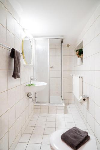 a white bathroom with a shower and a sink at Monteurzimmer in Nordhausen