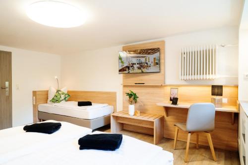 a bedroom with two beds and a desk and a table at Monteurzimmer in Nordhausen