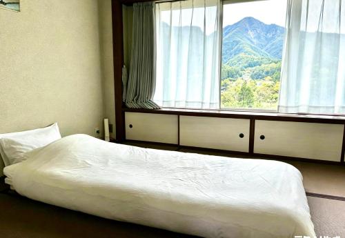 a bedroom with a bed and a large window at Ajisai Coral Princess Villa in Shirahama