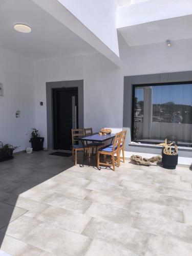a dining room with a table and chairs and a large window at Vromolithos View House in Vromolithos