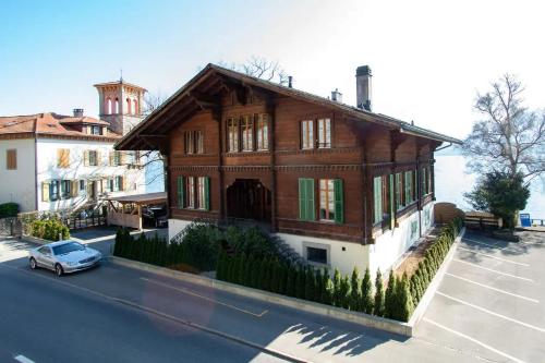 a house with a car parked in front of it at Villa Alti Ländte in Oberhofen am Thunersee