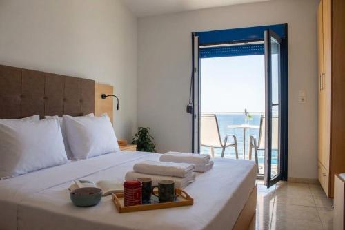 a bedroom with a bed with a view of the ocean at OdeSea Aegean Studios in Plomari