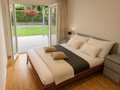 a bedroom with a bed with pillows and a window at Skender's Apartment in Interlaken