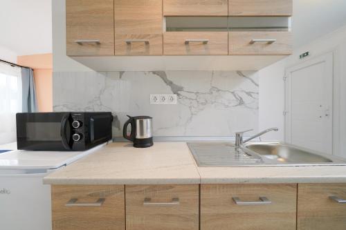 a kitchen with a sink and a microwave at Studios Tasos Bi 2 in Chrysi Ammoudia
