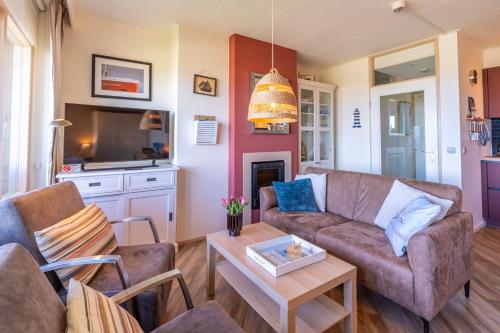 a living room with a couch and a table at Appartementencomplex Juliana 158 in De Koog