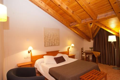 a hotel room with a bed and a chair at Hotel Florido in Sort