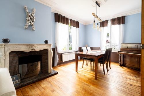 a dining room with a table and a fireplace at L'Oasis Familiale Arborée - Welkeys in Vincennes