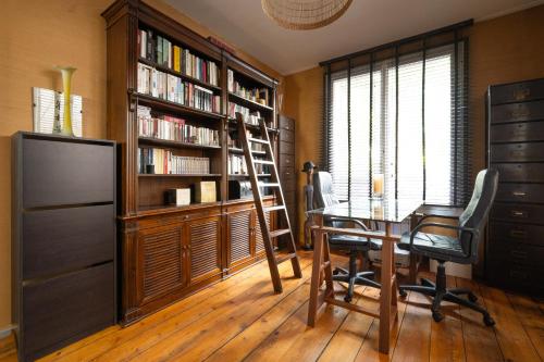 a dining room with a table and a book shelf at L'Oasis Familiale Arborée - Welkeys in Vincennes