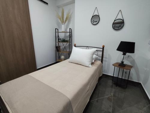 a bedroom with a bed with a pillow and a lamp at Argiros Apartments in Kefalos