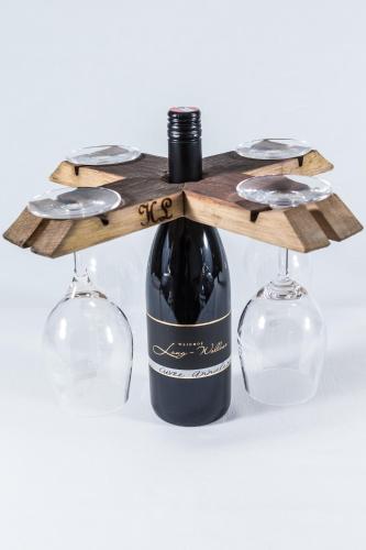 a bottle of wine on a wooden shelf with two wine glasses at Pension Julia & Haus Elisabeth - Wallner's Hofheuriger & Weinhof in Mörbisch am See
