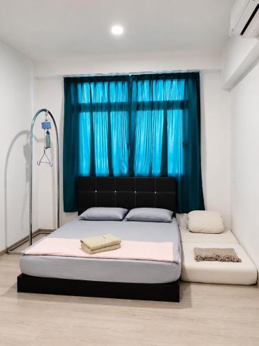 a bedroom with a bed with a blue curtain at d 'ATHIF Homestay Samarahan 2 in Kuching