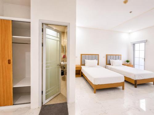 a bedroom with two beds and a walk in closet at SD HOTEL Taytay in Taytay