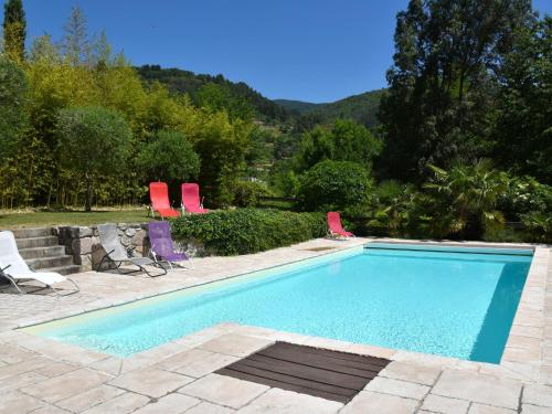 a swimming pool with two lawn chairs at Holiday Home in Ardèche near Château de Ventadour in Fabras