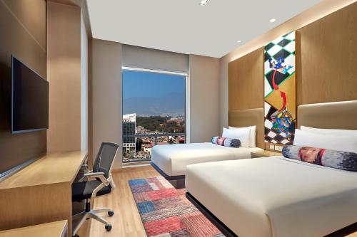 a hotel room with two beds and a window at Aloft by Marriott Kathmandu Thamel in Kathmandu