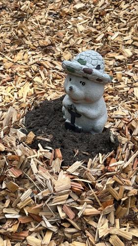 a stuffed animal with a hat sitting on a pile of wood chips at Ihr Ferien Hotel Brunnenhof in Suhlendorf