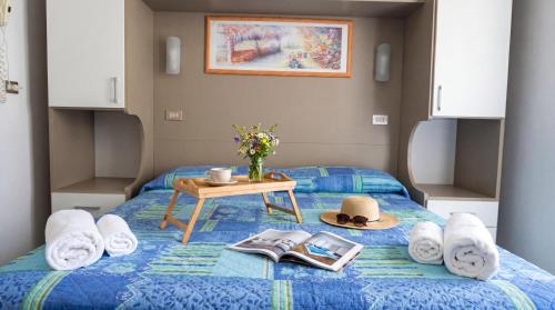 a bed with towels and hats and a table on it at B&B Hotel Villa Nora in Bellaria-Igea Marina