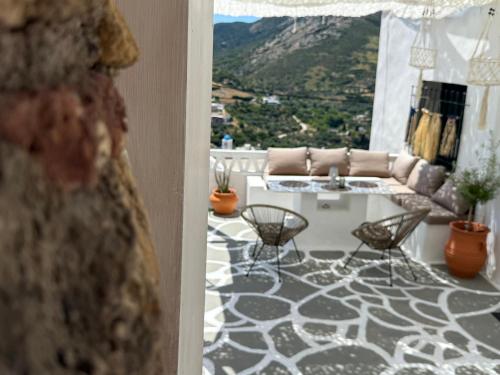 a living room with a couch and a table and chairs at Vasiliki Skyros Castle View in Skiros